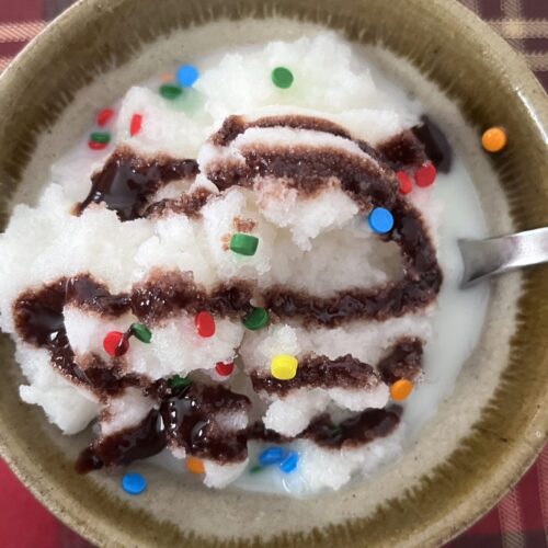 snow ice cream in a bowl with chocolate syrup and sprinkles