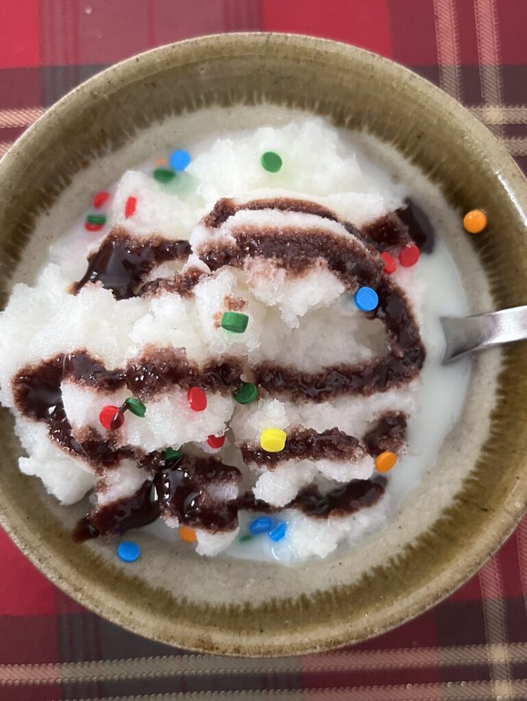 snow ice cream in a bowl with chocolate syrup and sprinkles