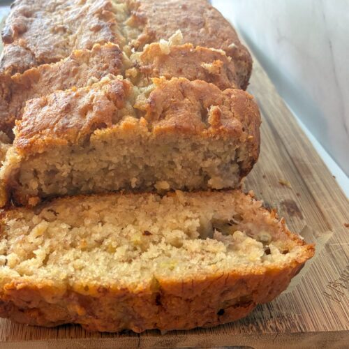 Eggless banana bread on a cutting board sliced open