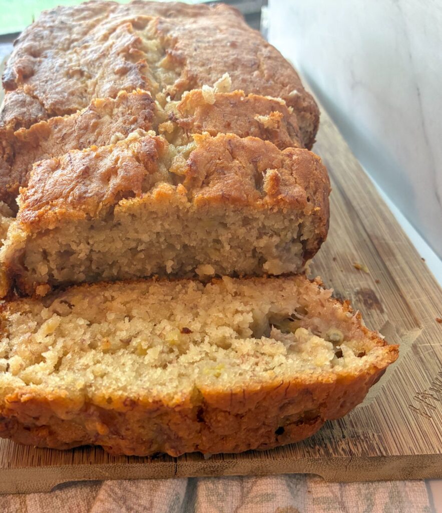 Eggless banana bread on a cutting board sliced open