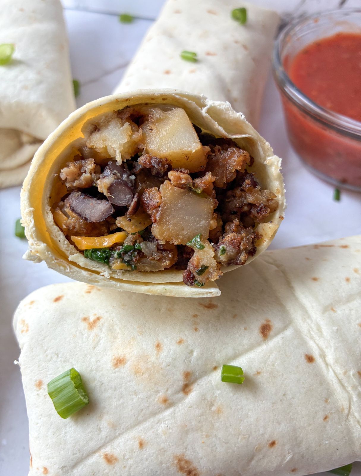 Breakfast burrito without eggs cut in half