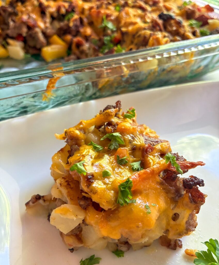 Eggless breakfast casserole slice on a plate with the casserole behind it