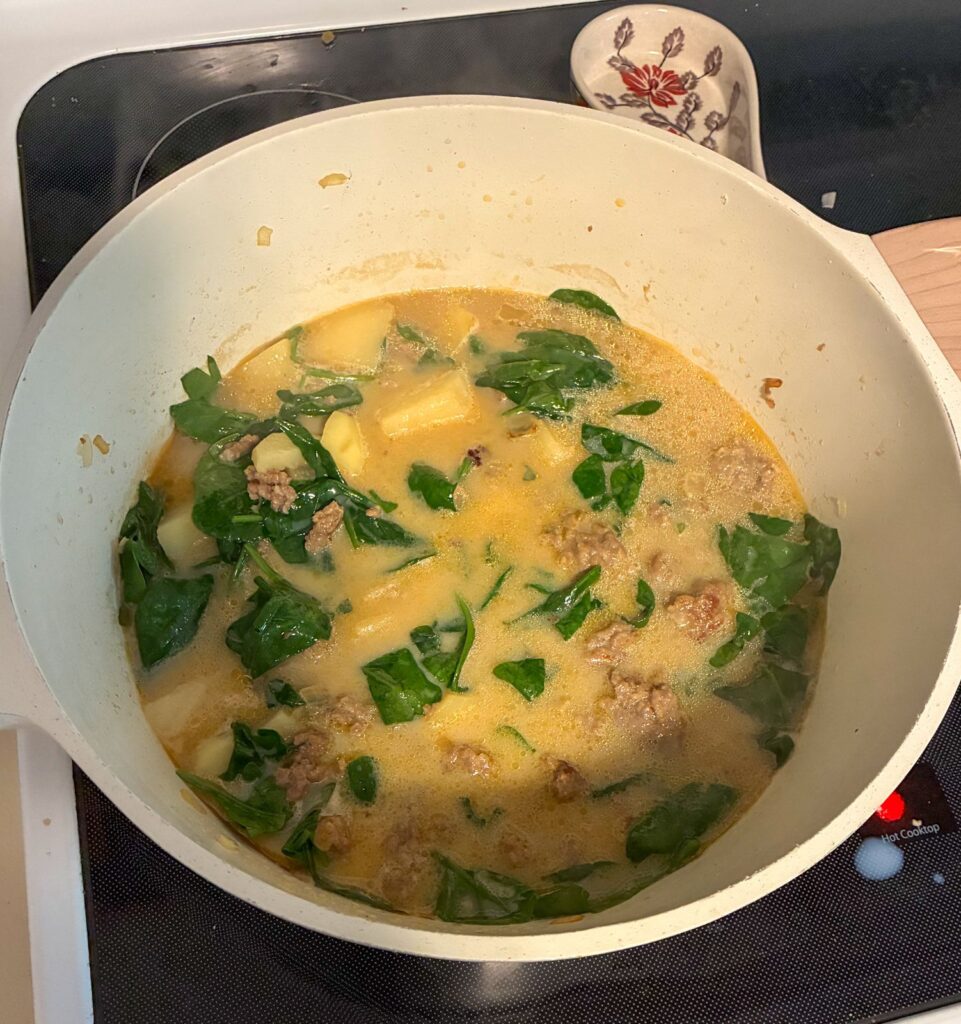 finished sausage, potato, and spinach soup in a large pot