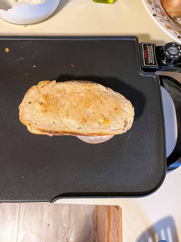 sourdough turkey melt being toasted on a griddle