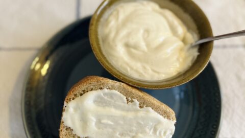 Eggless mayo served in a bowl and on a piece of toast