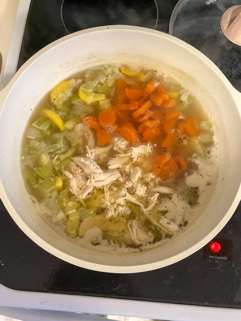 Chicken and vegetables cooked in the broth in a large stock pot