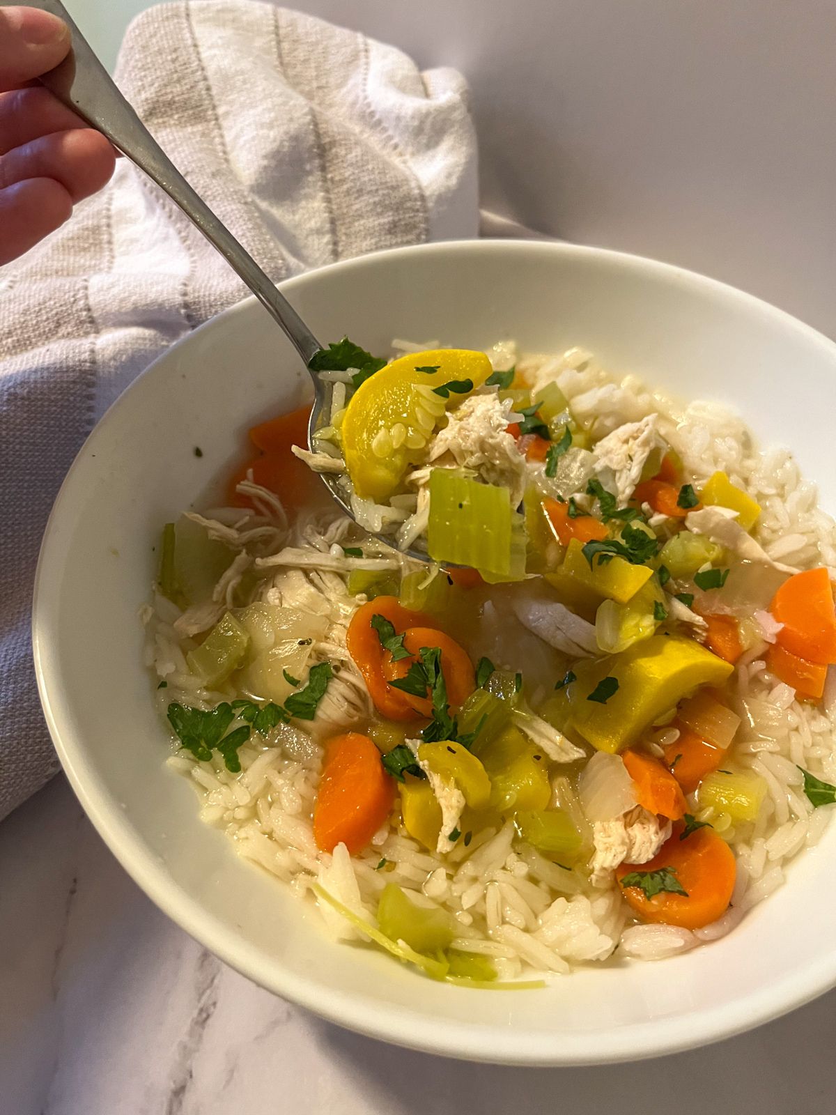 chicken and rice soup served in a bowl with a spoon