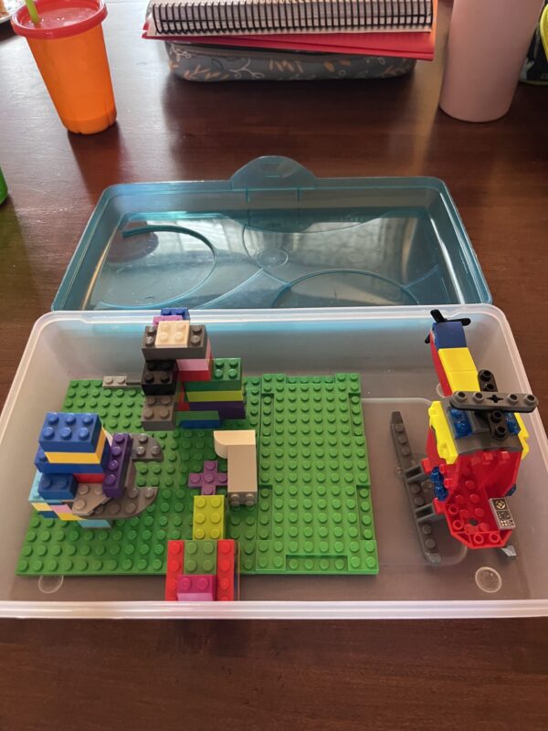 Lego pieces inside a large pencil box holder for kids to play with while traveling