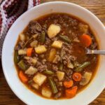 hamburger soup served in a bowl with a spoon