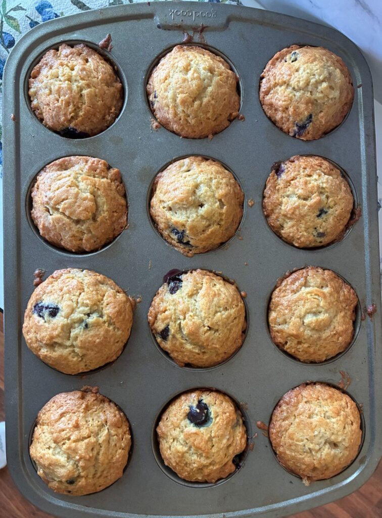 Sourdough discard banana blueberry muffins in a baking pan fresh out of the oven