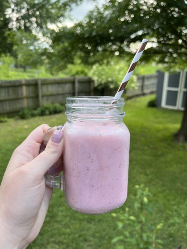 strawberry banana smoothie served in a glass with a straw