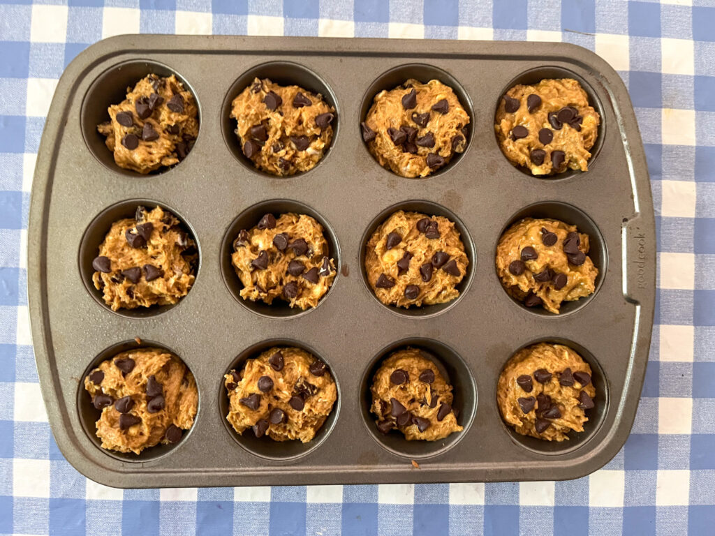 Batter in muffin tins ready to bake sourdough discard pumpkin chocolate chip muffins