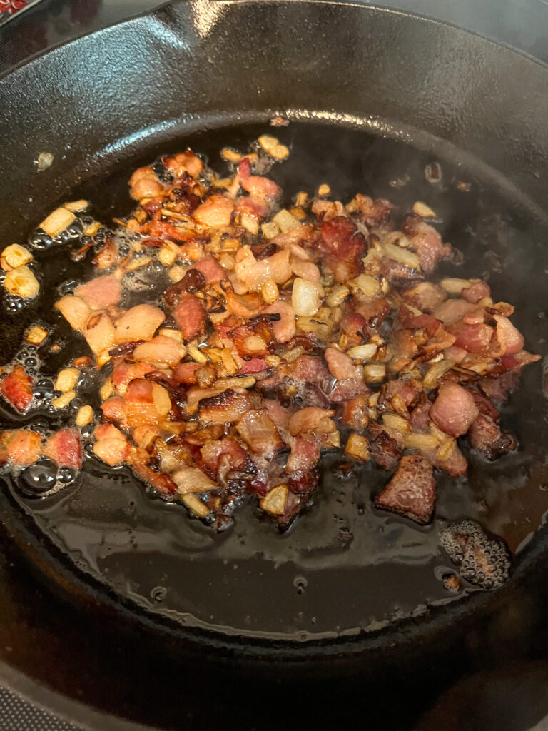 sautéed bacon and onion in cast iron skillet