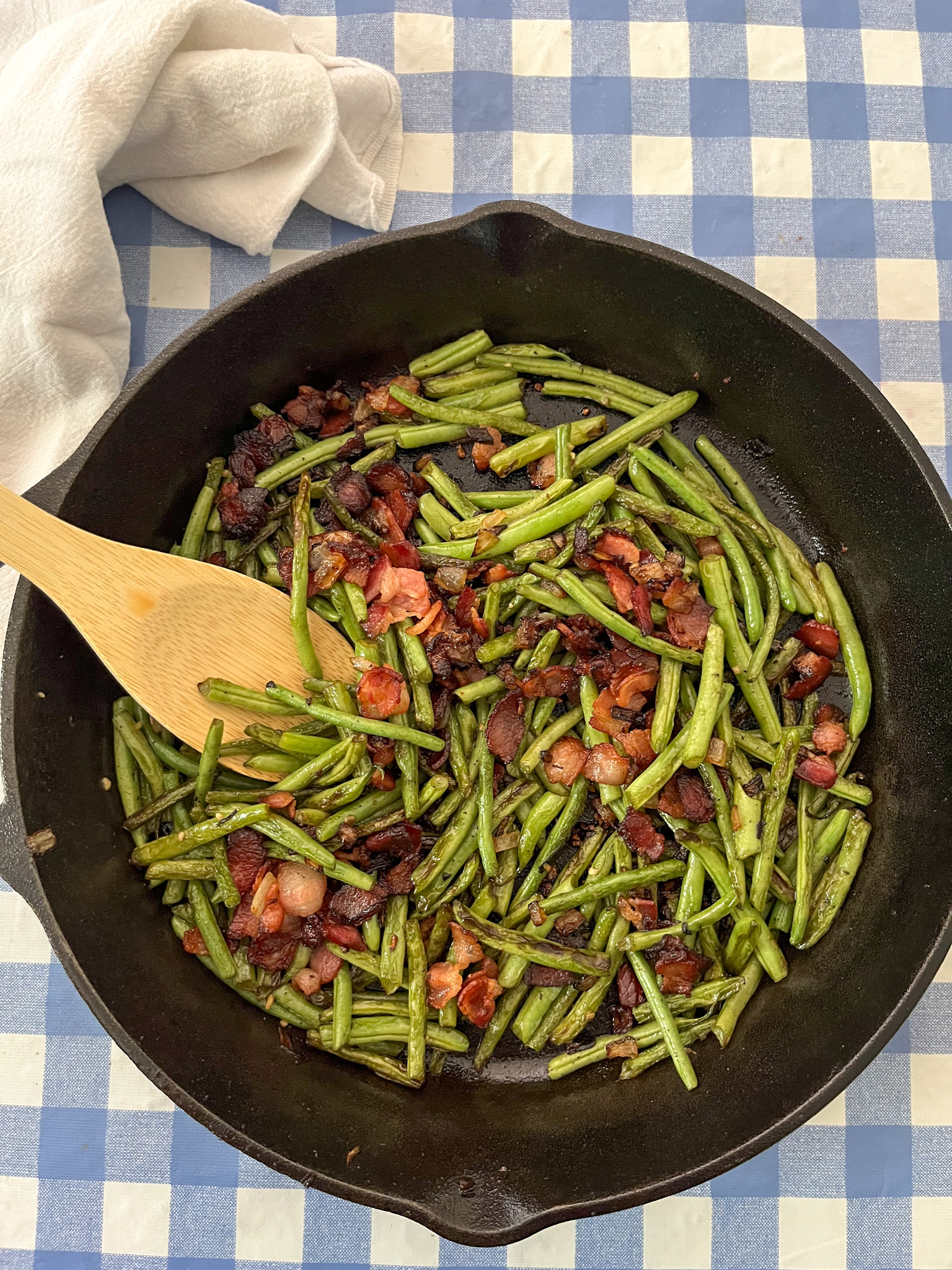 sauteed green beans, bacon, and onion in cast iron skillet