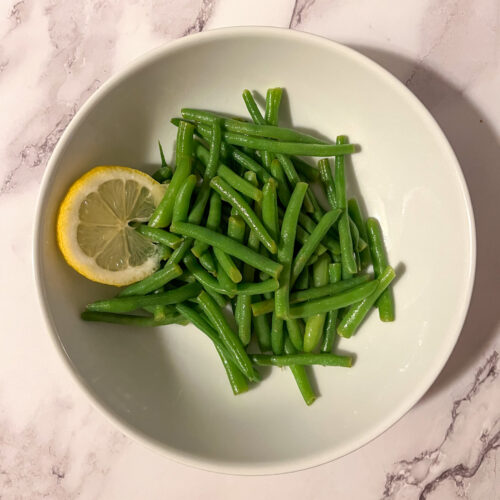Green beans with lemon served in a bowl
