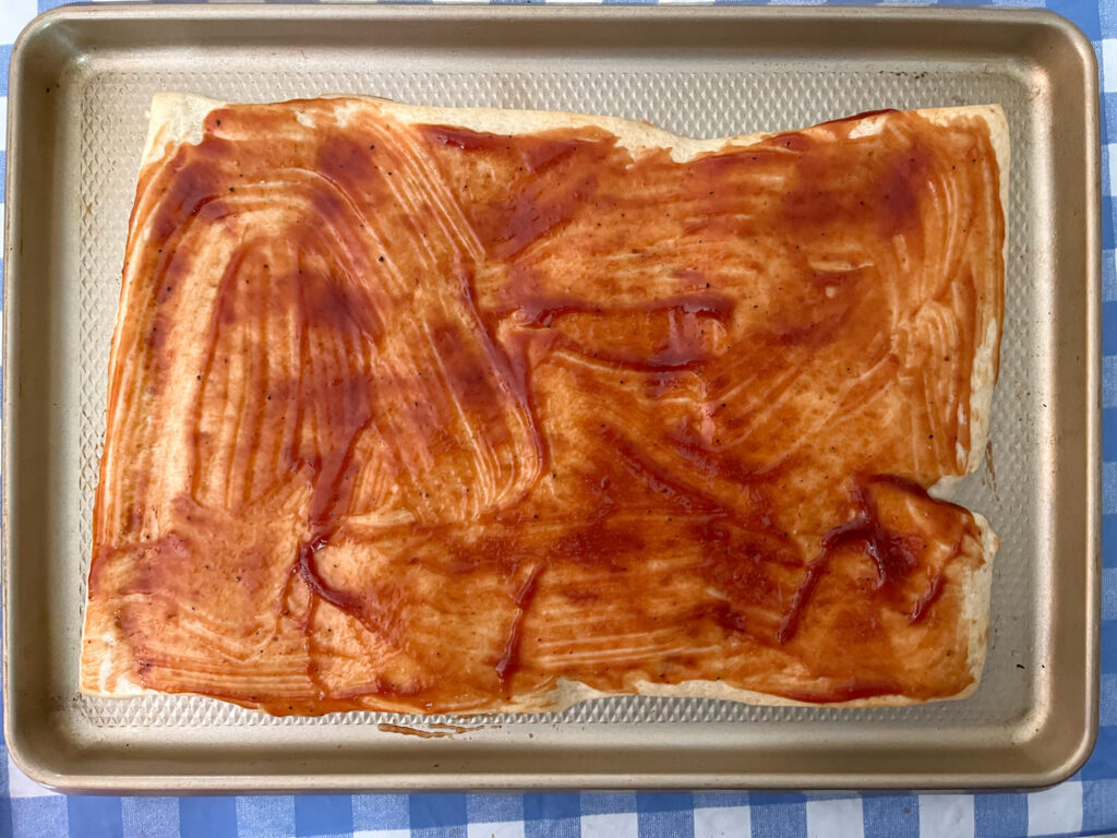 Prebaked pizza with bbq sauce on it