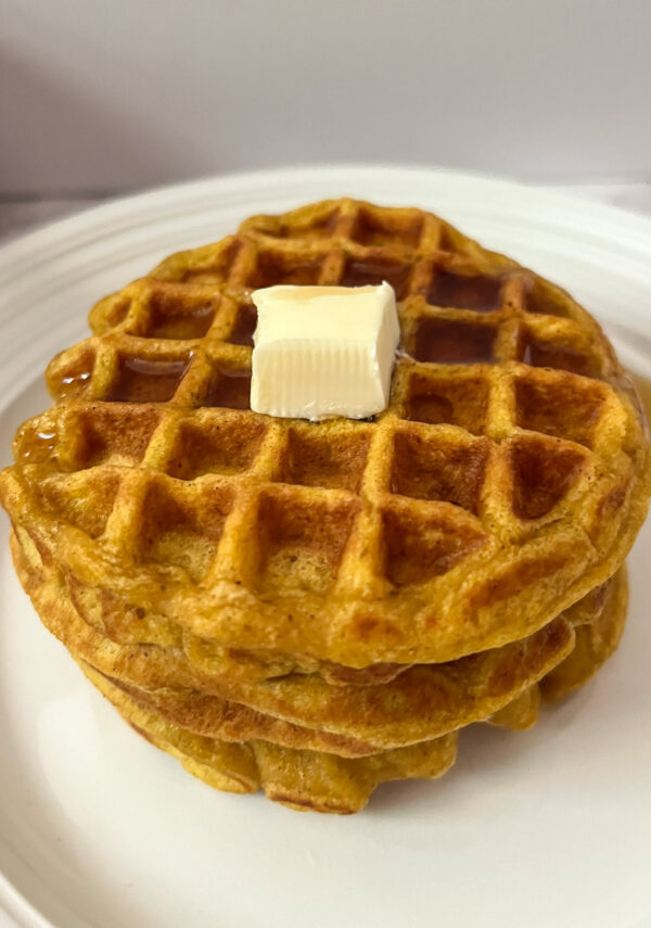 2 Pumpkin waffles with no egg stacked up with butter and maple syrup