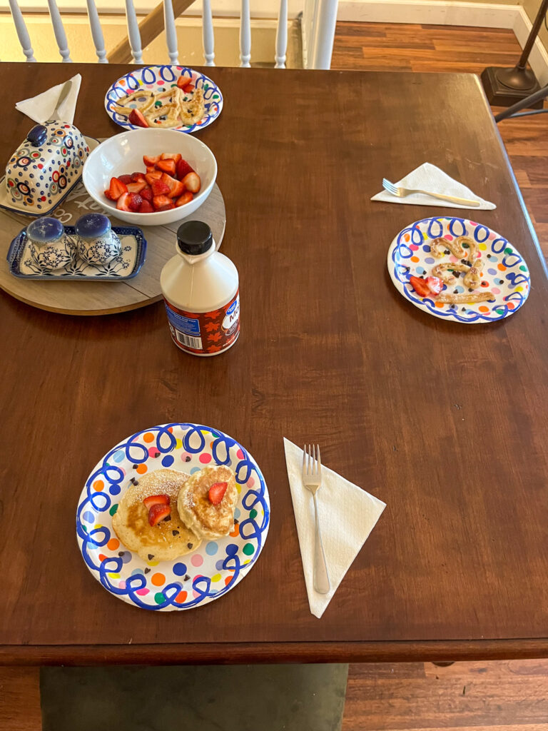 Table set with 3 plates with back to school letter and number pancakes and strawberries