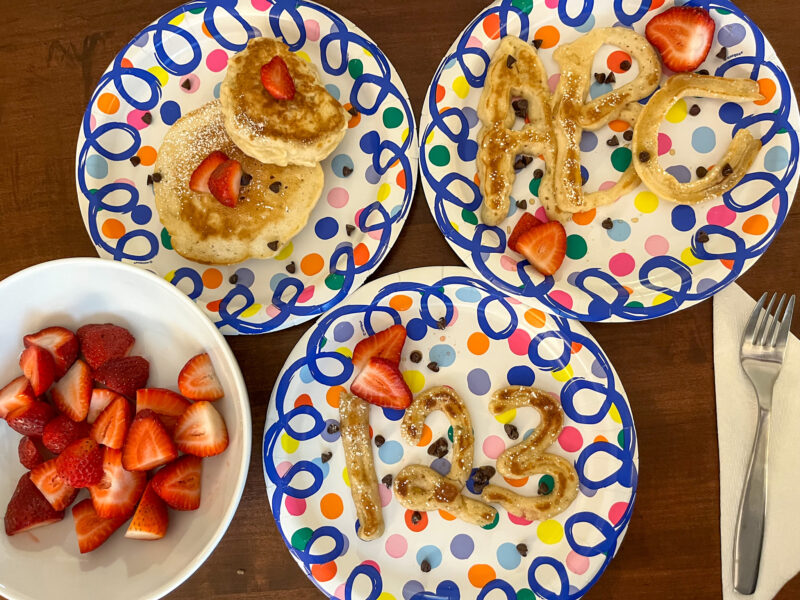 3 plates of pancakes and 1 bowl of strawberries