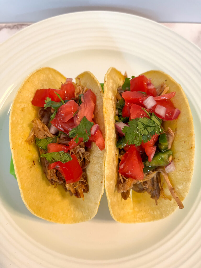 Leftover pulled pork tacos in 2 shells and covered in pico de gallo