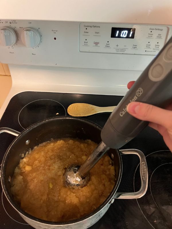 Immersion blender being used in pumpkin spice applesauce