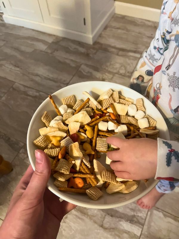 bowl full of nut free trail mix with a child reaching in