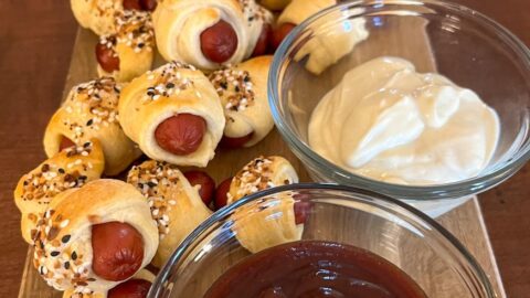 pigs in a blanket served on a tray with 3 sauces