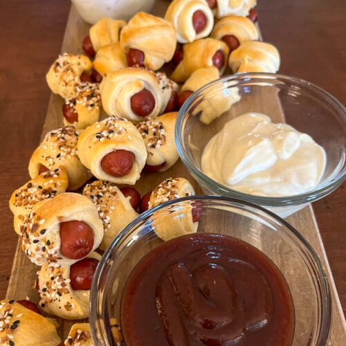 pigs in a blanket served on a tray with 3 sauces