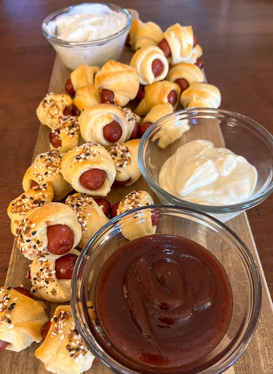 pigs in a blanket served on a tray with 3 sauces