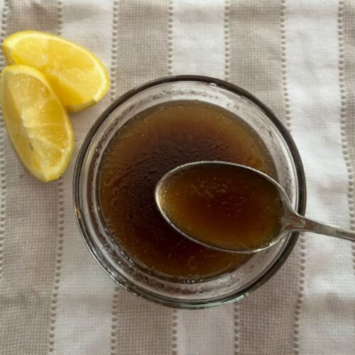 Lemon Balsamic salad dressing in a bowl with a spoon scooping some out.