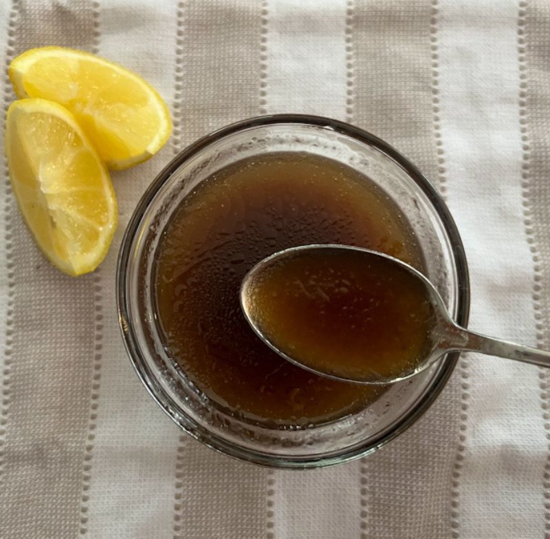 Lemon Balsamic salad dressing in a bowl with a spoon scooping some out.