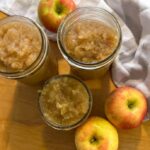 maple cinnamon apples in cans surrounded by apples