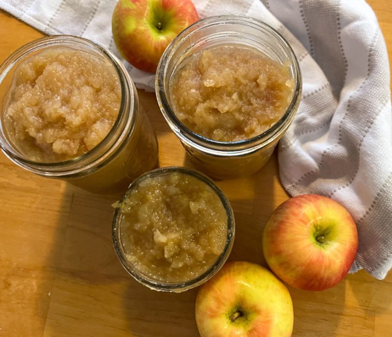 maple cinnamon apples in cans surrounded by apples