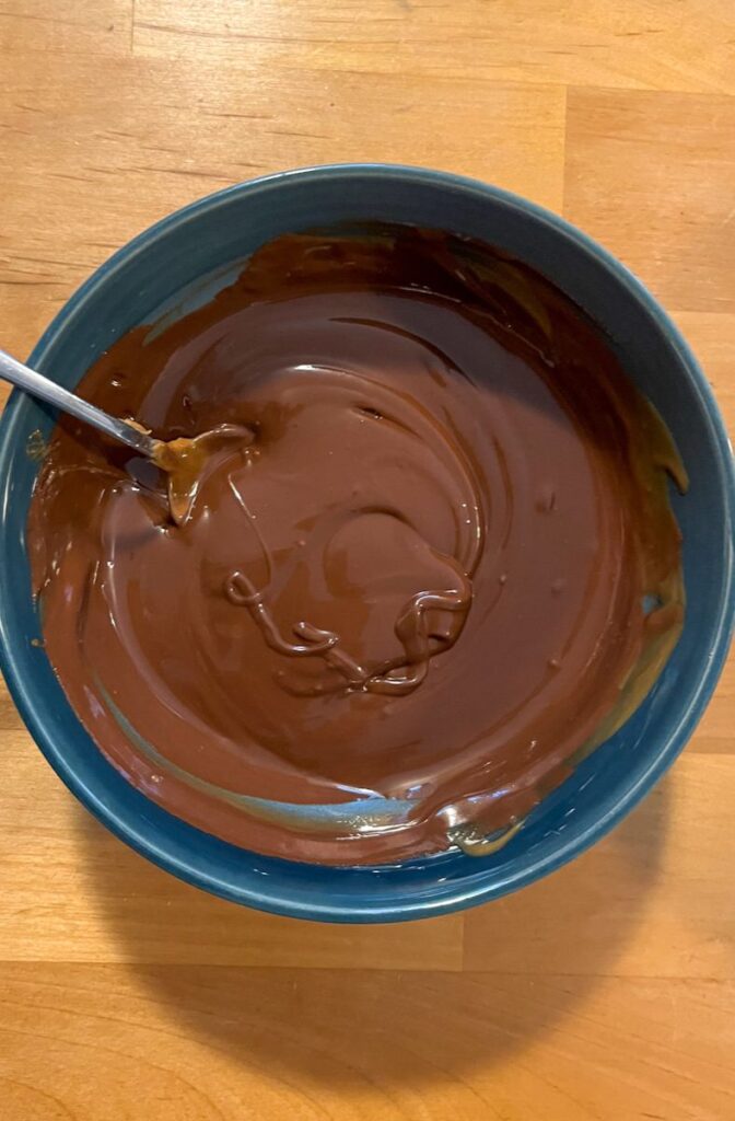 A bowl with a mixture of melted chocolate chips and cookie butter