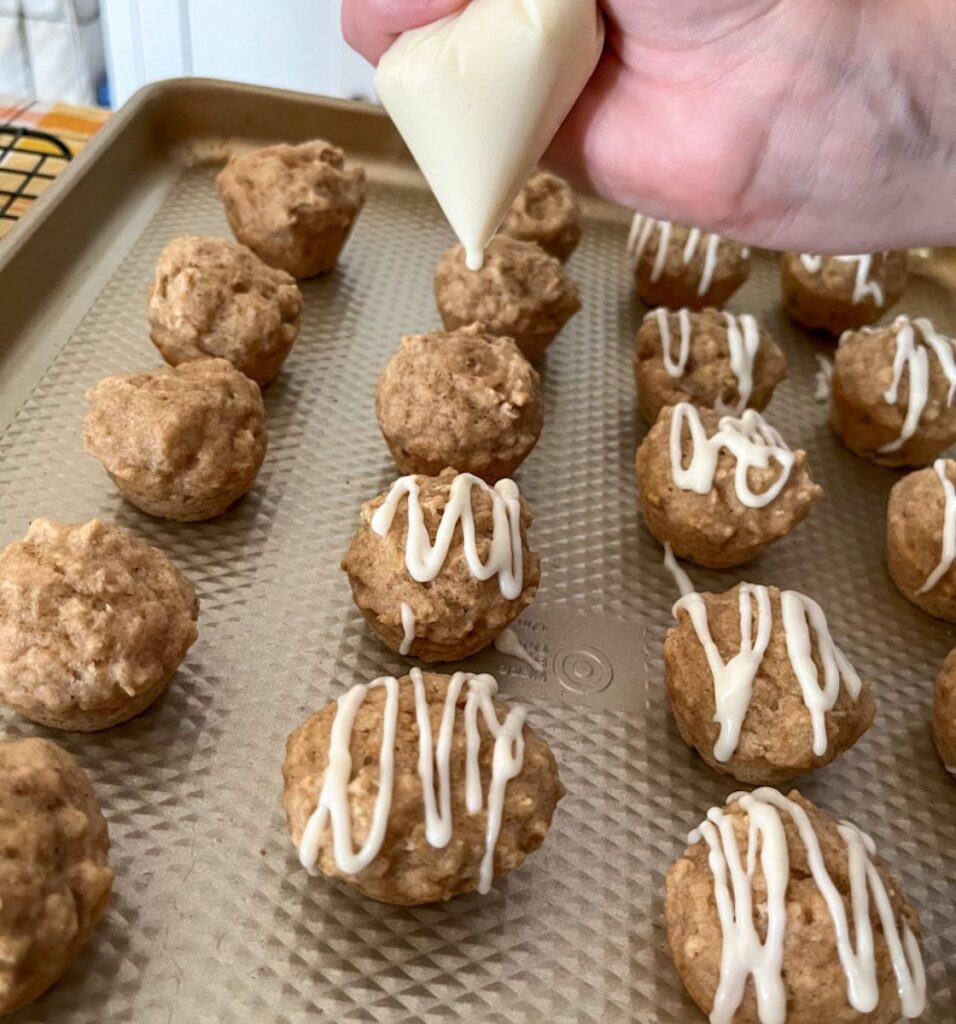 applesauce muffins without eggs getting cream cheese glaze piped on them