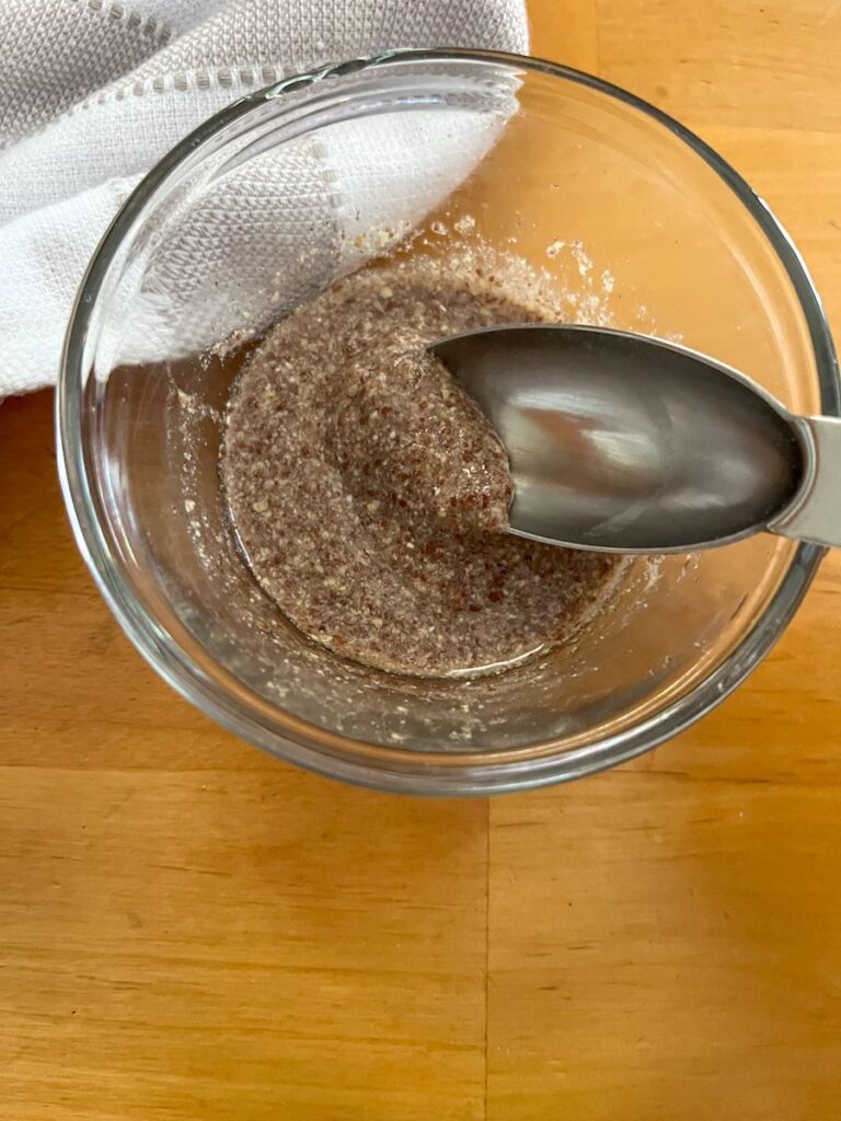 small bowl with a flax egg in it and a spoon scooping some out