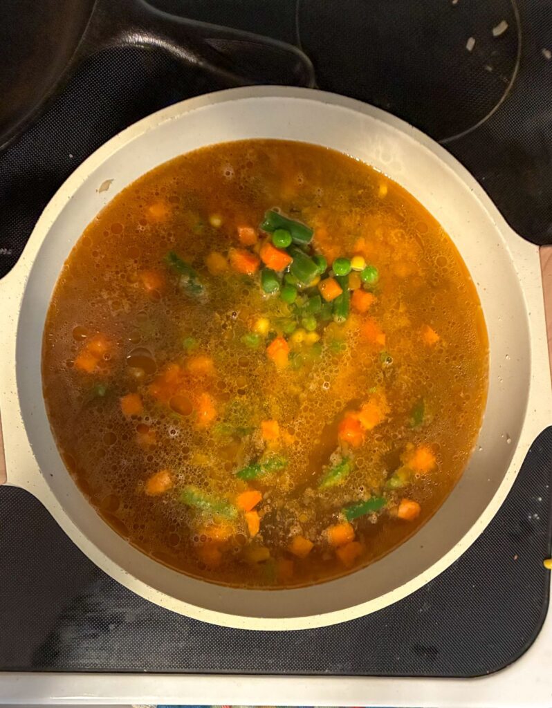 The soup halfway cooked in a large soup pot