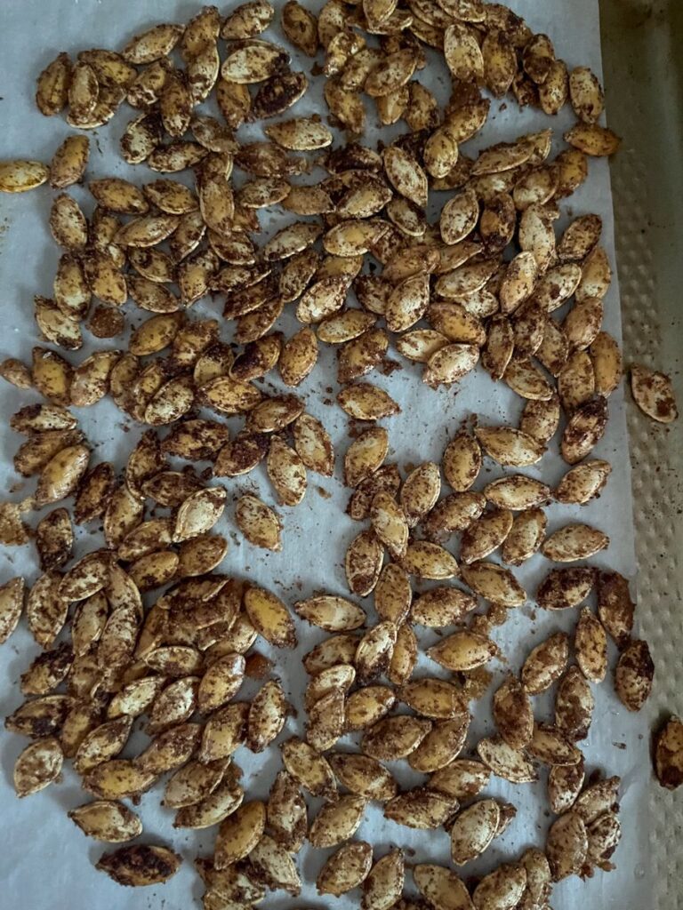 pumpkin seeds on a baking sheet with cinnamon sugar
