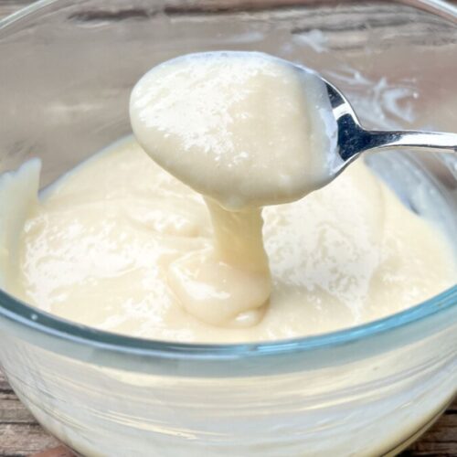 cream cheese glaze with a spoon scooping some out