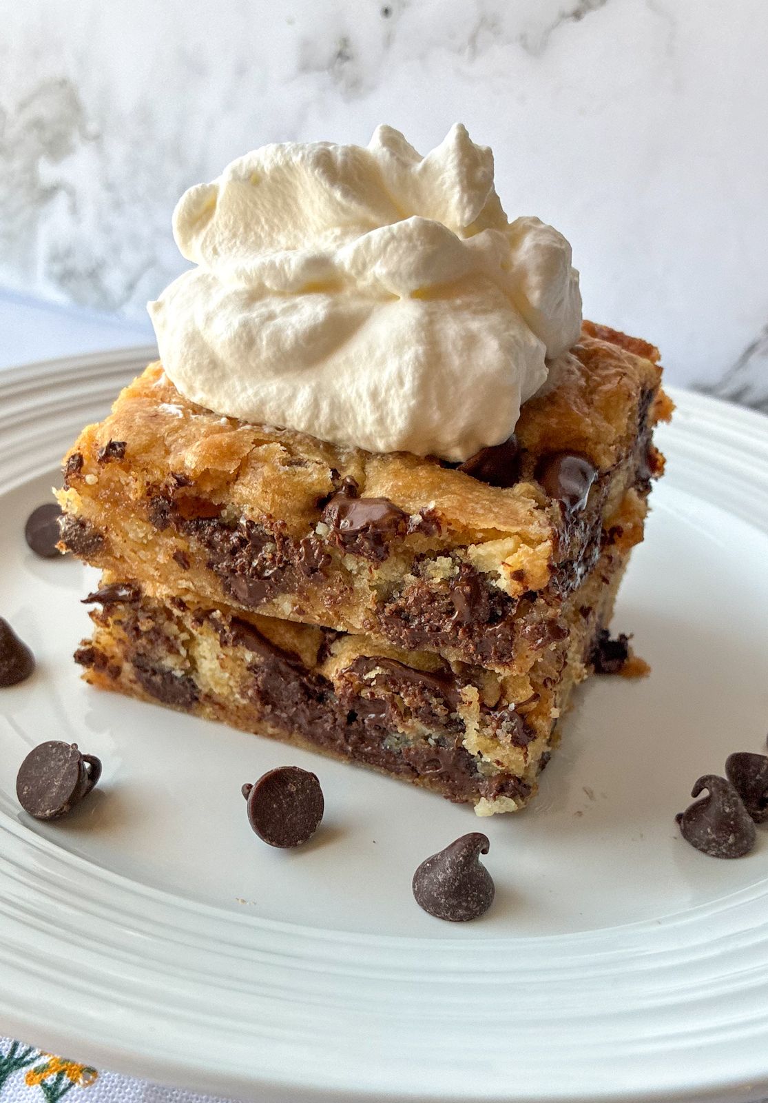 Two pieces of cookie bars with whipped cream on top