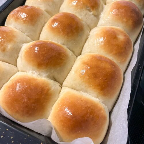 Soft dinner rolls fresh out of the oven and brushed with butter