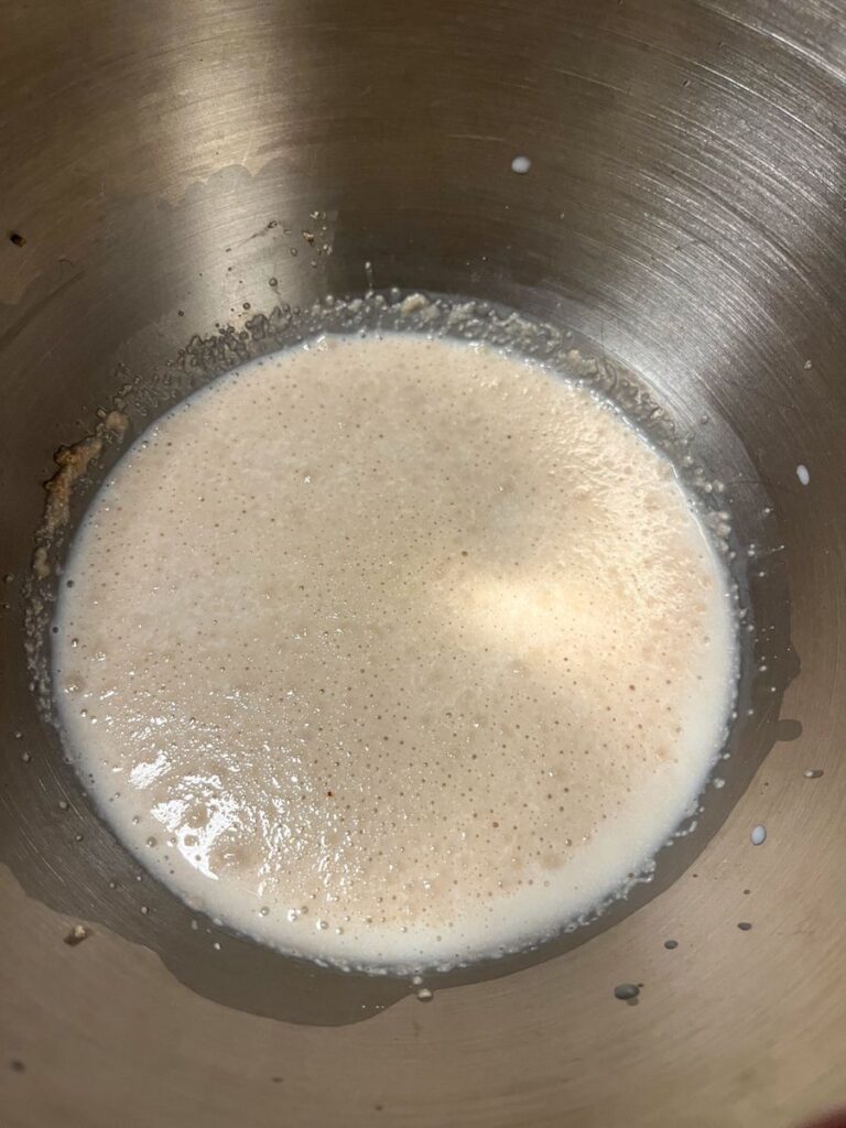 a bowl of active dry yeast, milk, and sugar. The picture shows the foam on the top needed prior to baking.