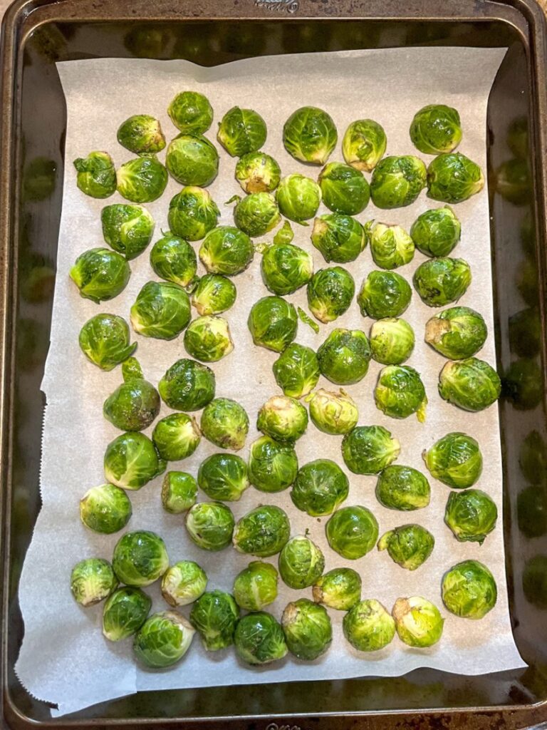 Uncooked brussel sprouts halved and laying on a baking sheet
