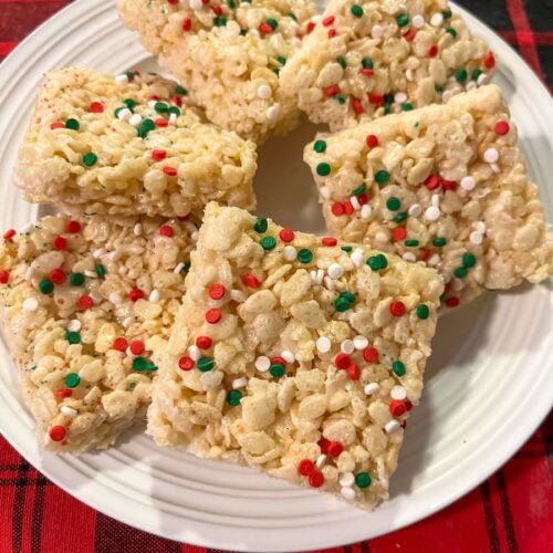 Christmas rice krispie treats cut into squares and served on a plate