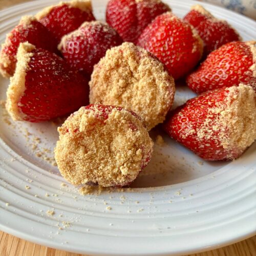 Several cheesecake stuffed strawberries displayed on a plate