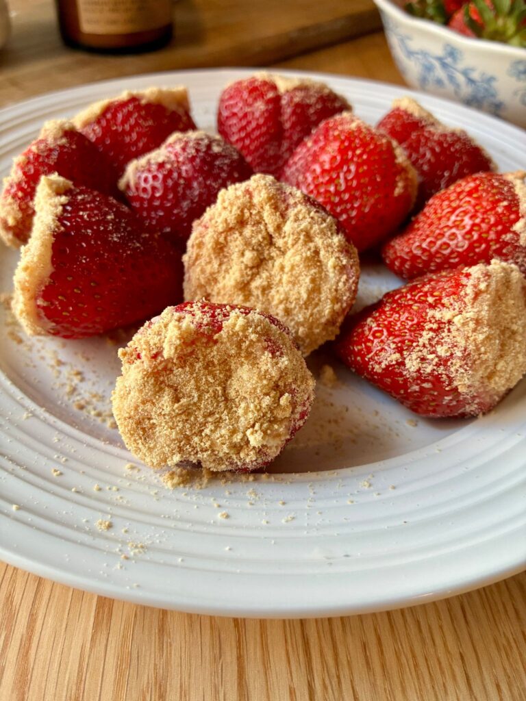 Several cheesecake stuffed strawberries displayed on a plate