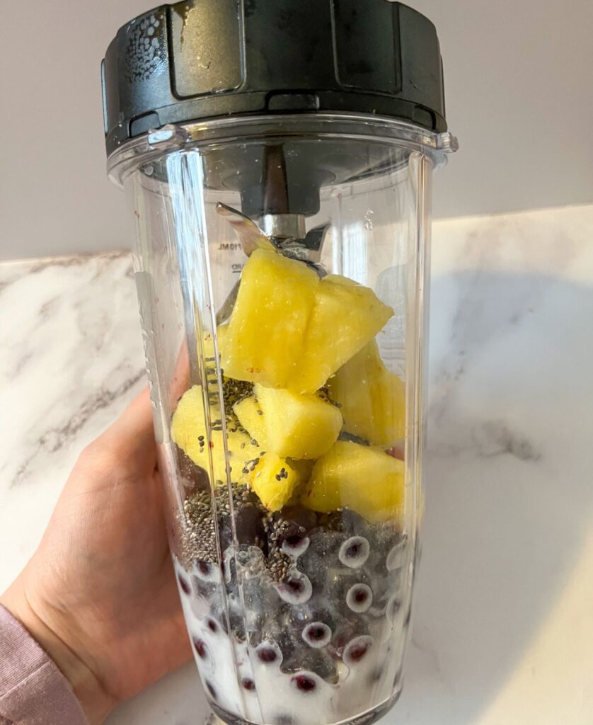 Ingredients of a smoothie bowl in a blender before it has been blended up