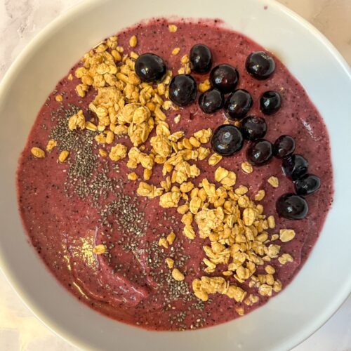 blueberry smoothie bowl served in a bowl with toppings on it