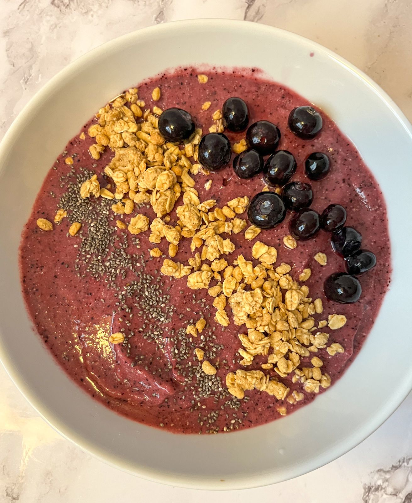 blueberry smoothie bowl served in a bowl with toppings on it
