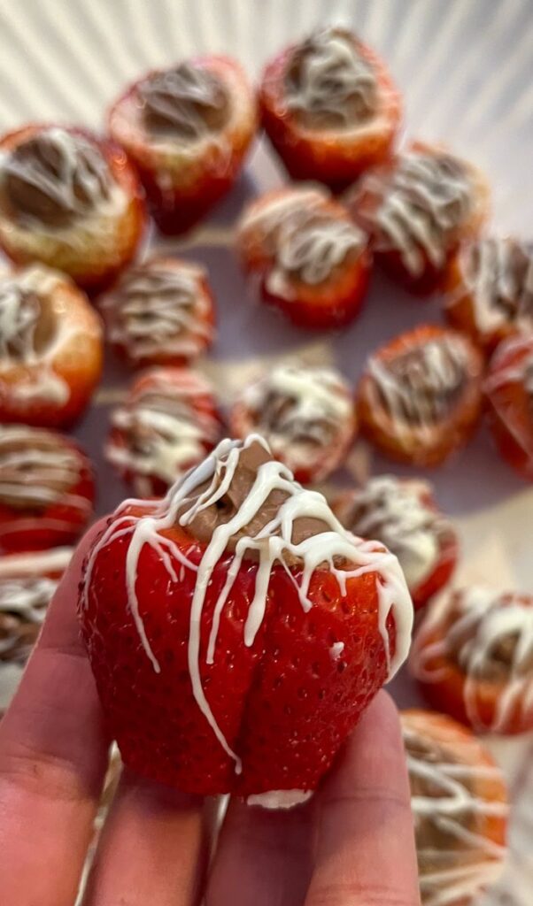 One Chocolate stuffed strawberry being held close to the camera 